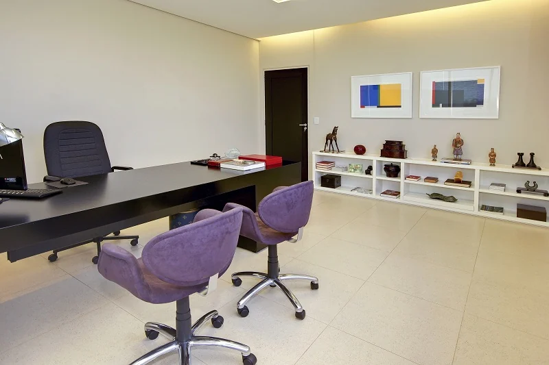 Consultório da Clínica Basile, com mesa médica e duas poltronas